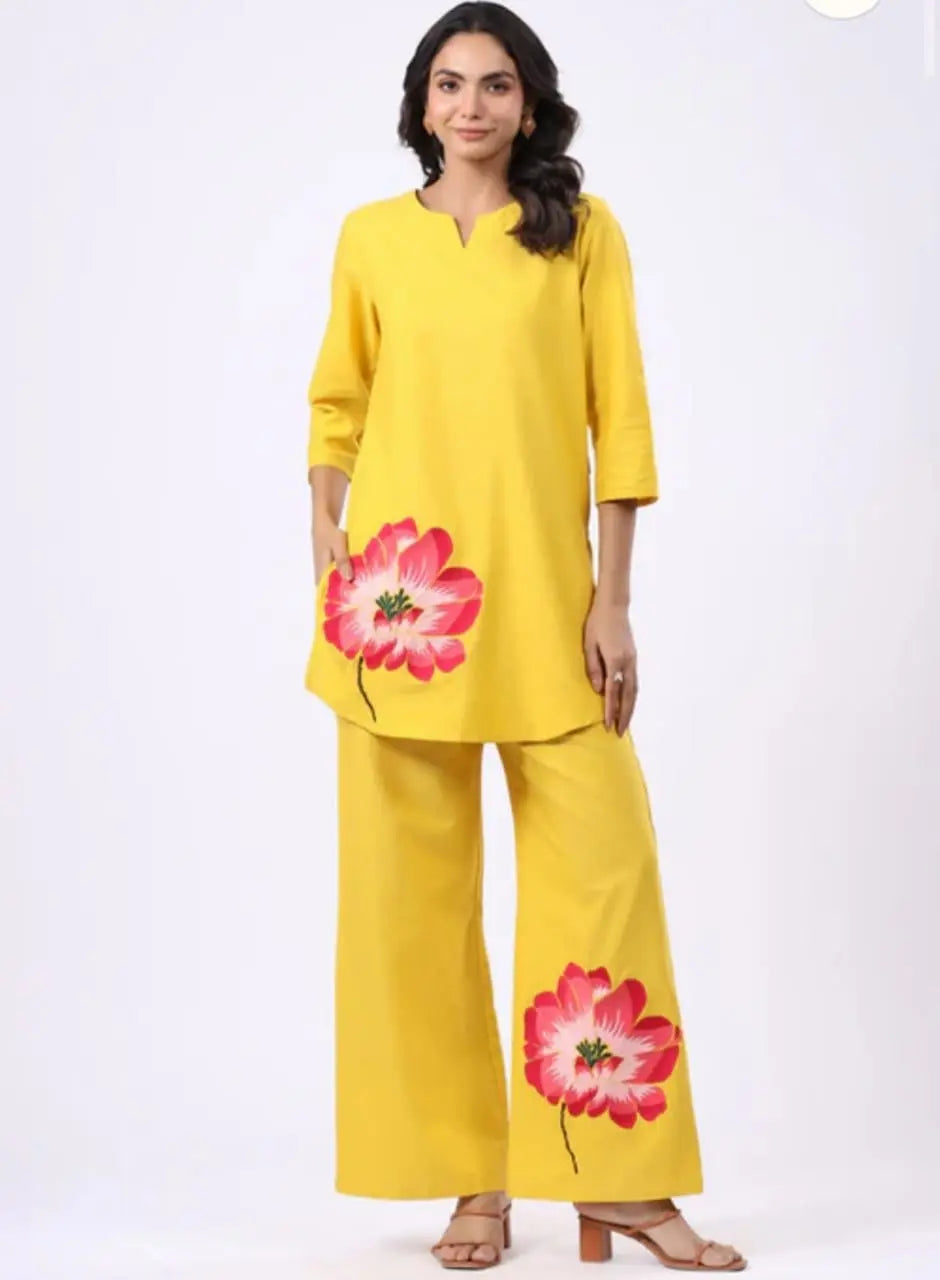 Mustard yellow kurta with large pink floral print paired with matching wide-leg palazzo pants with floral detail.