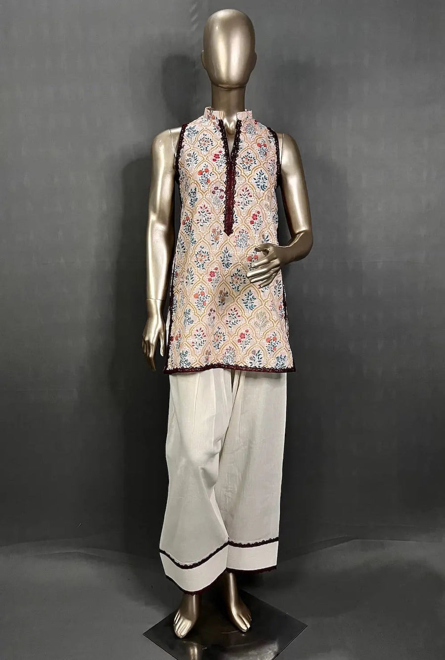 Sleeveless floral print kurti with black buttoned neckline paired with white farshi palazzo pants with black trim.