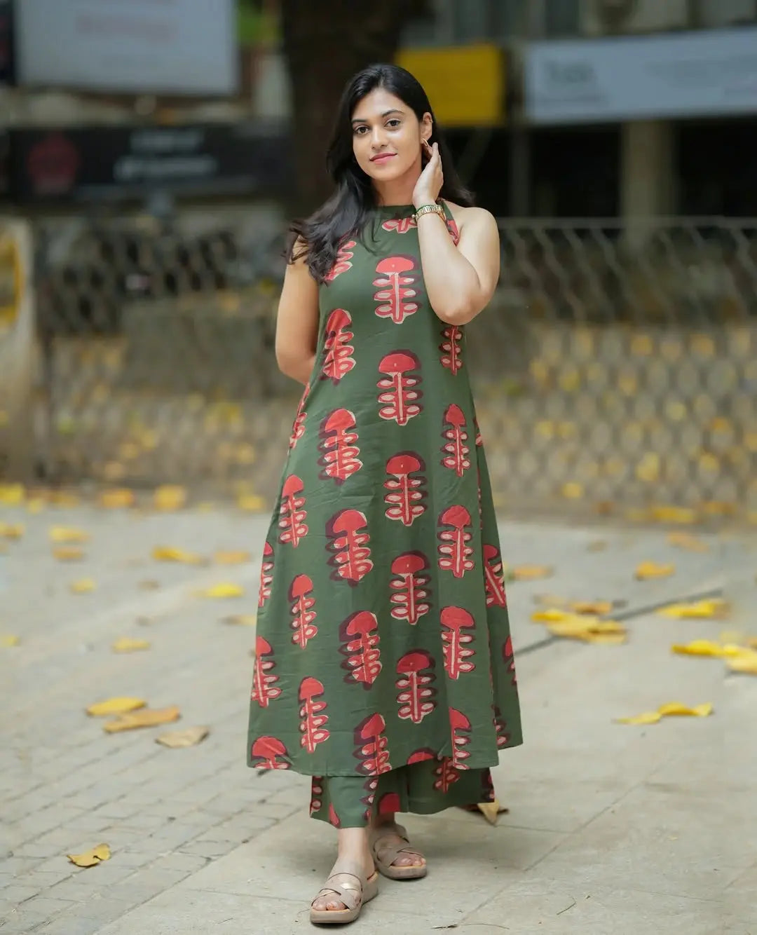 Women’s olive green sleeveless kurti with red leaf print paired with matching wide-leg palazzo pants.