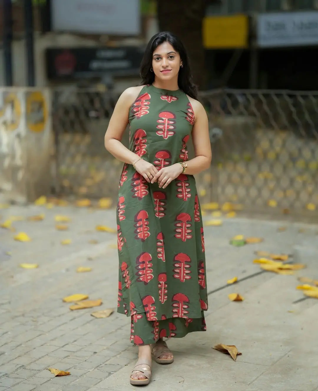 Women’s olive green sleeveless kurti with red leaf prints paired with matching palazzo pants.