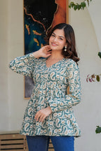 Green paisley printed long kurti with flared hem and full sleeves on a smiling woman.