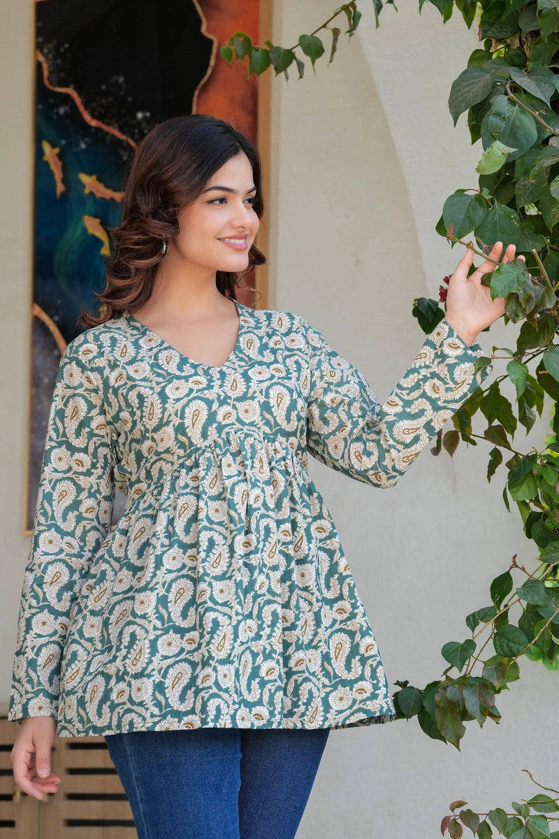 Green paisley printed long kurti with flared hem and full sleeves worn with blue jeans.