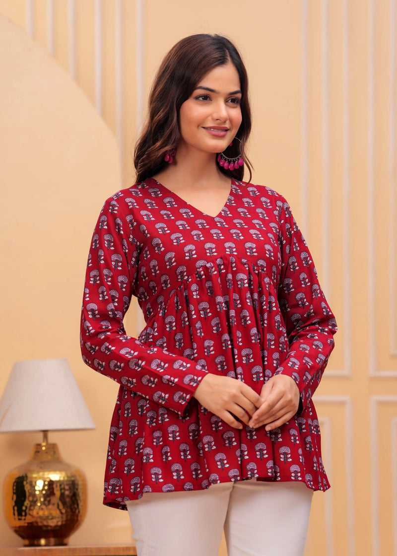 Red long kurti top with all-over white geometric print, V-neck, and flared silhouette.