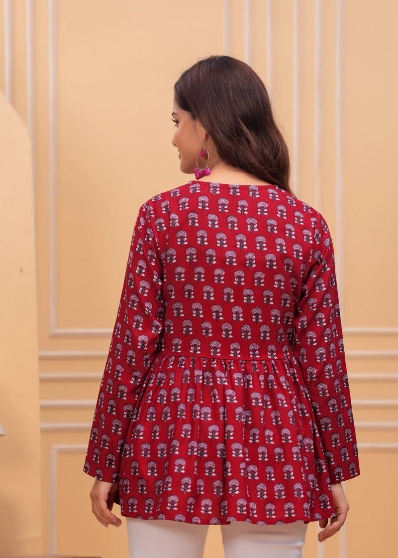 Red printed long kurti top with flared hem and full sleeves on a model seen from the back.