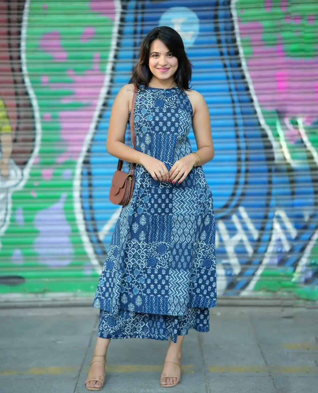 Blue sleeveless kurti with patchwork prints paired with matching palazzo pants and brown crossbody bag.