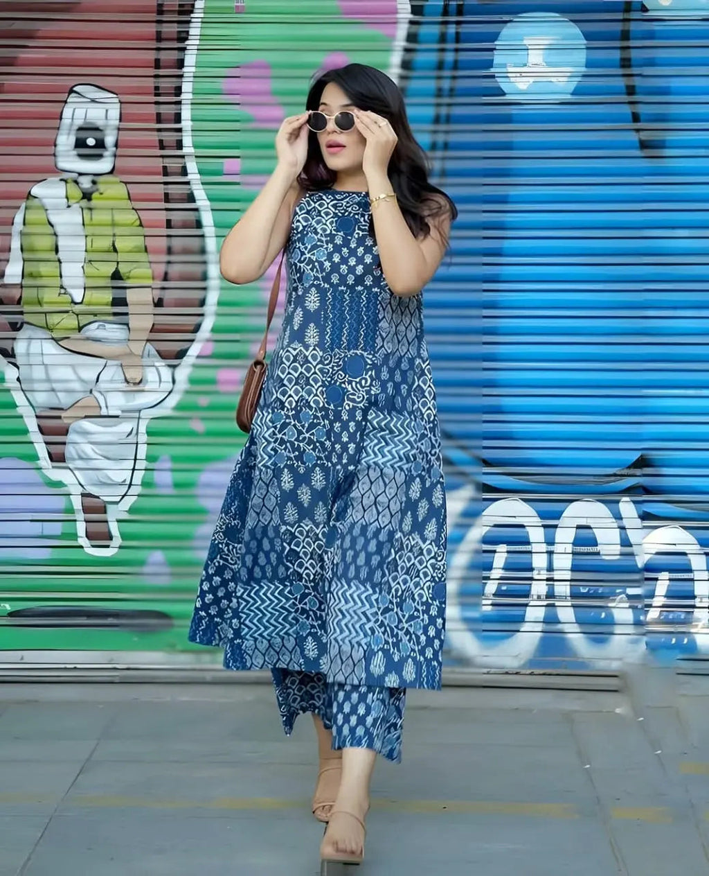 Blue ethnic printed sleeveless kurti with matching palazzo pants styled with sunglasses and beige heels.