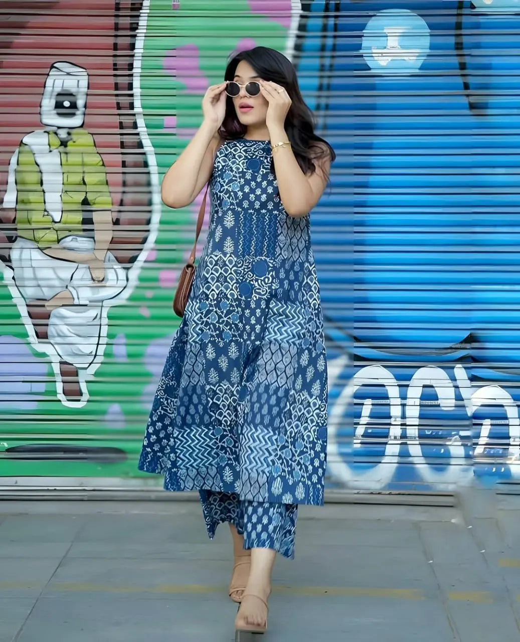 Blue ethnic printed sleeveless kurti with matching palazzo pants styled with sunglasses and beige heels.