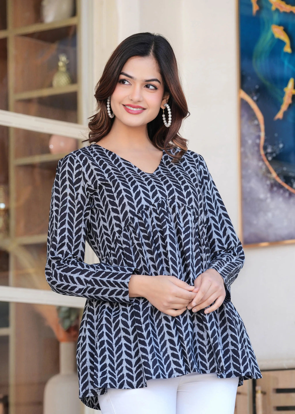 Black and white long kurti top with geometric leaf print and V-neck, worn by model.