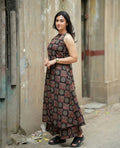 Sleeveless black and red patterned maxi dress with a fitted black corset belt at the waist.