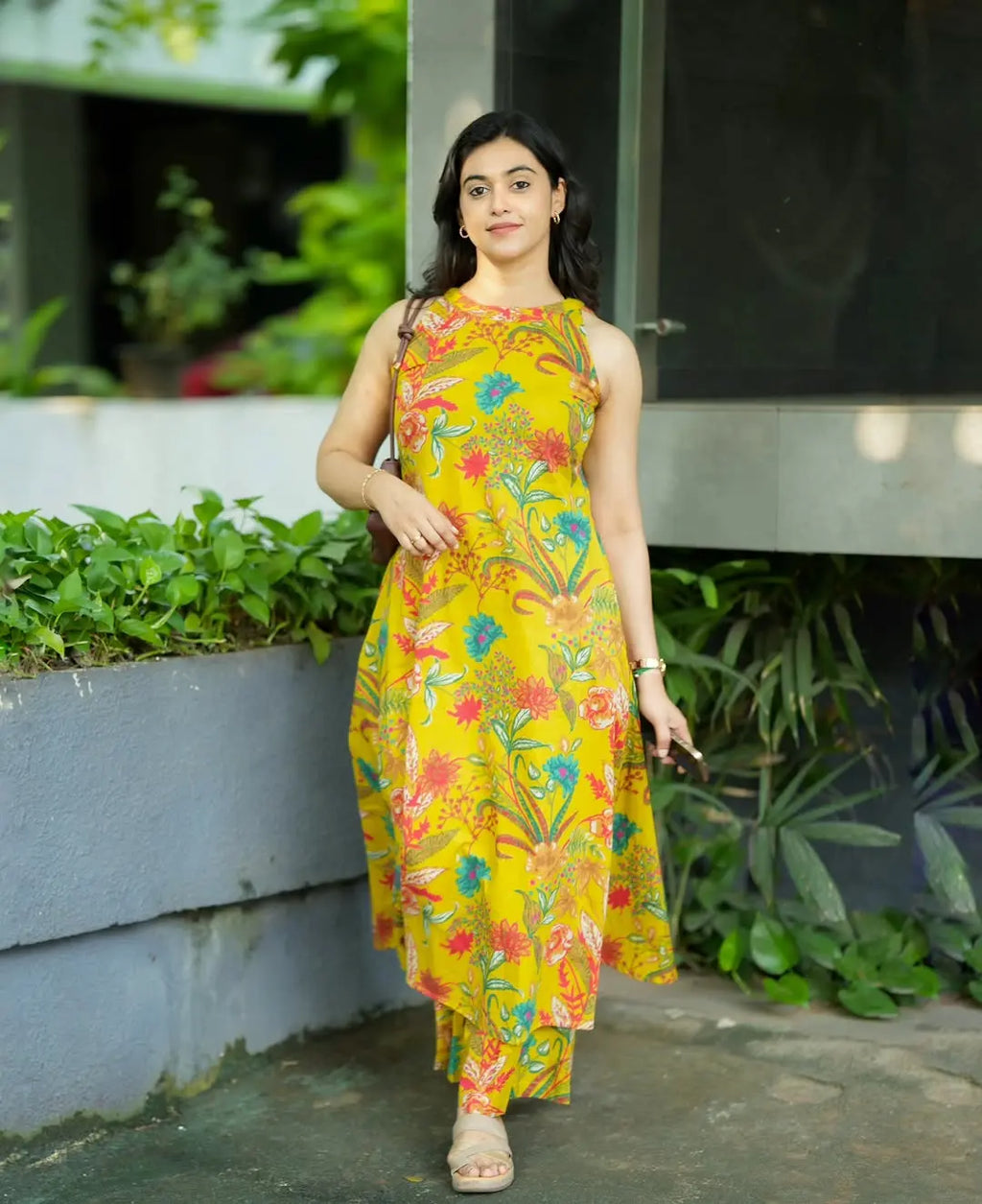 Sleeveless yellow kurta with blue and orange floral print paired with matching printed pants.