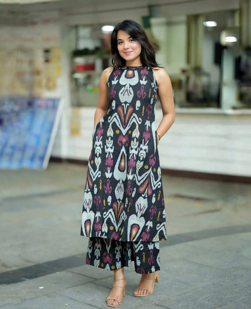 Black sleeveless printed corset dress with multicolor geometric patterns and tiered hem.