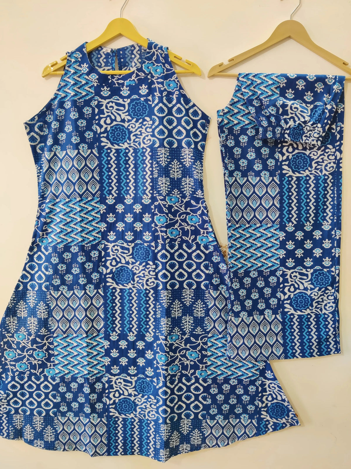 Blue sleeveless kurti with white geometric and floral prints paired with matching palazzo pants.