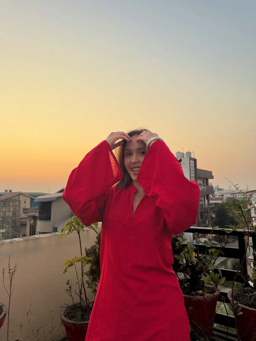 Red corset with long puffed sleeves and a v-neckline worn outdoors at sunset.