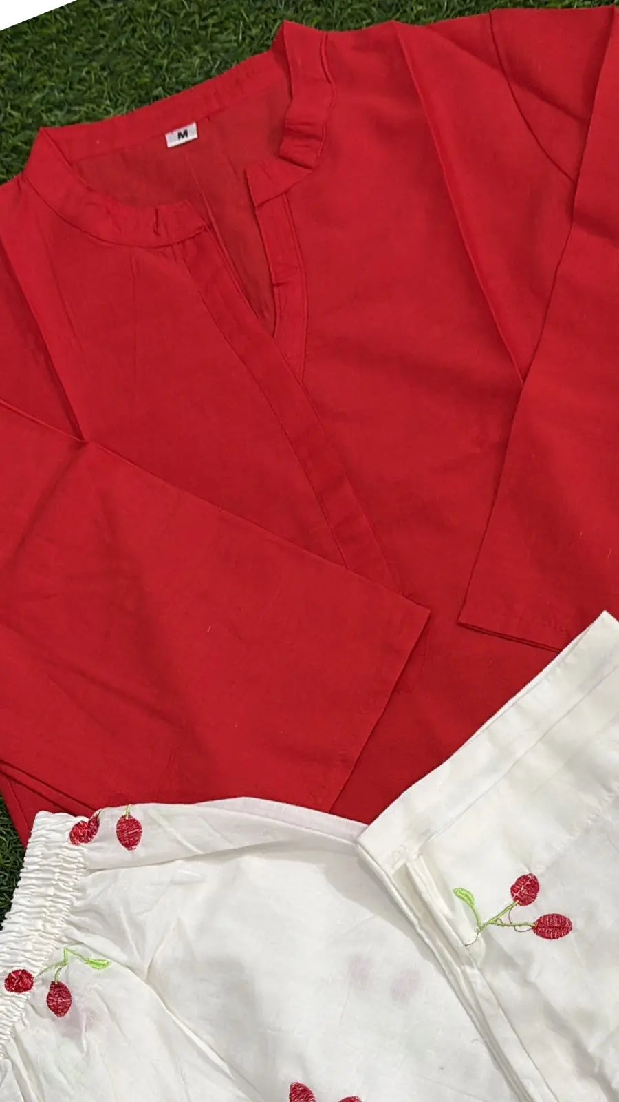 Bright red corset with front lacing detail paired with white fabric featuring cherry embroidery.