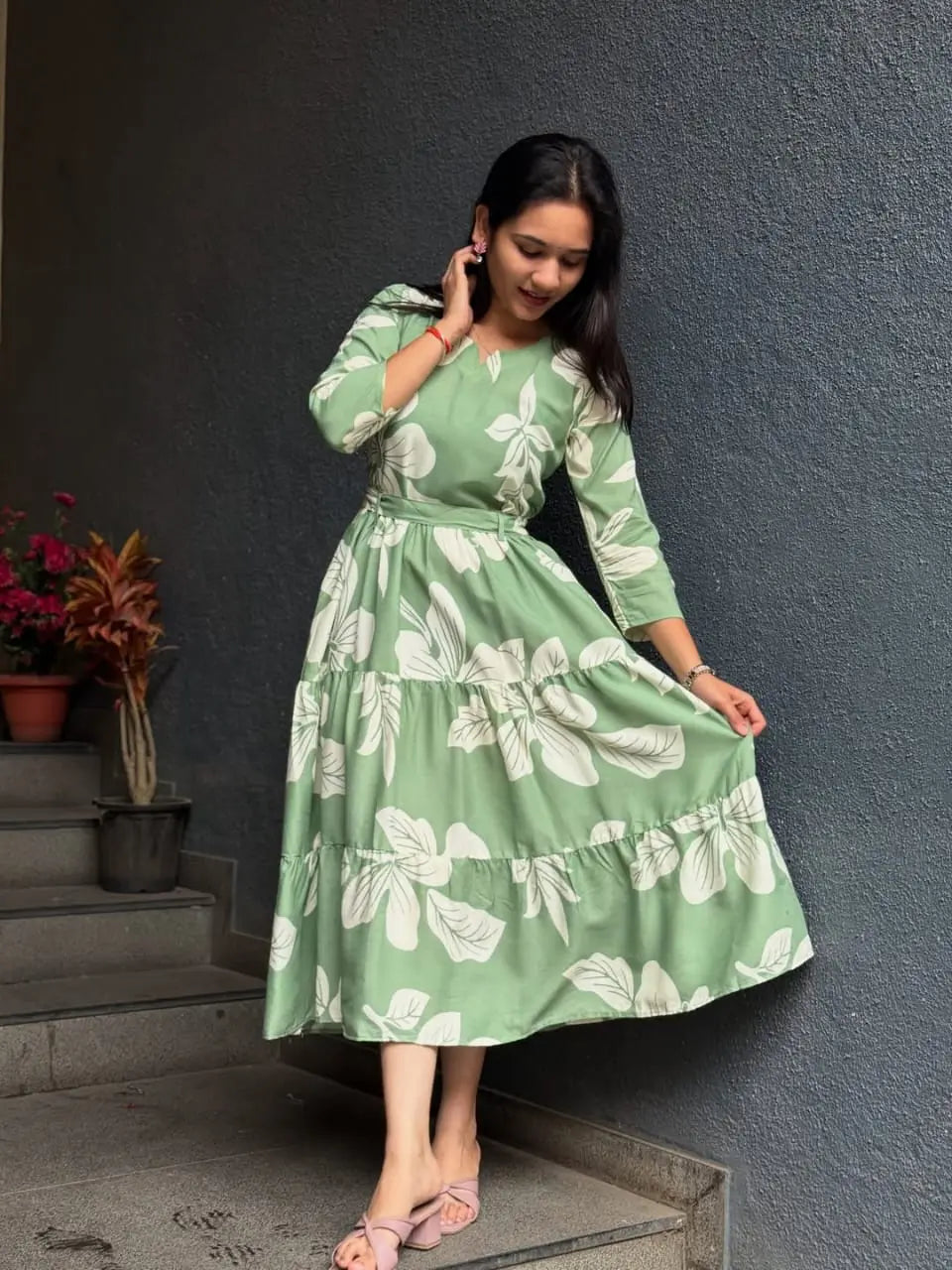Light green midi dress with large white floral print and long sleeves, styled with pink flats.