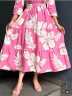 Pink short dress with large white floral print and three-quarter sleeves.