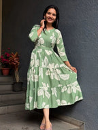 Green midi dress with white floral print, long sleeves, and a fitted waist.