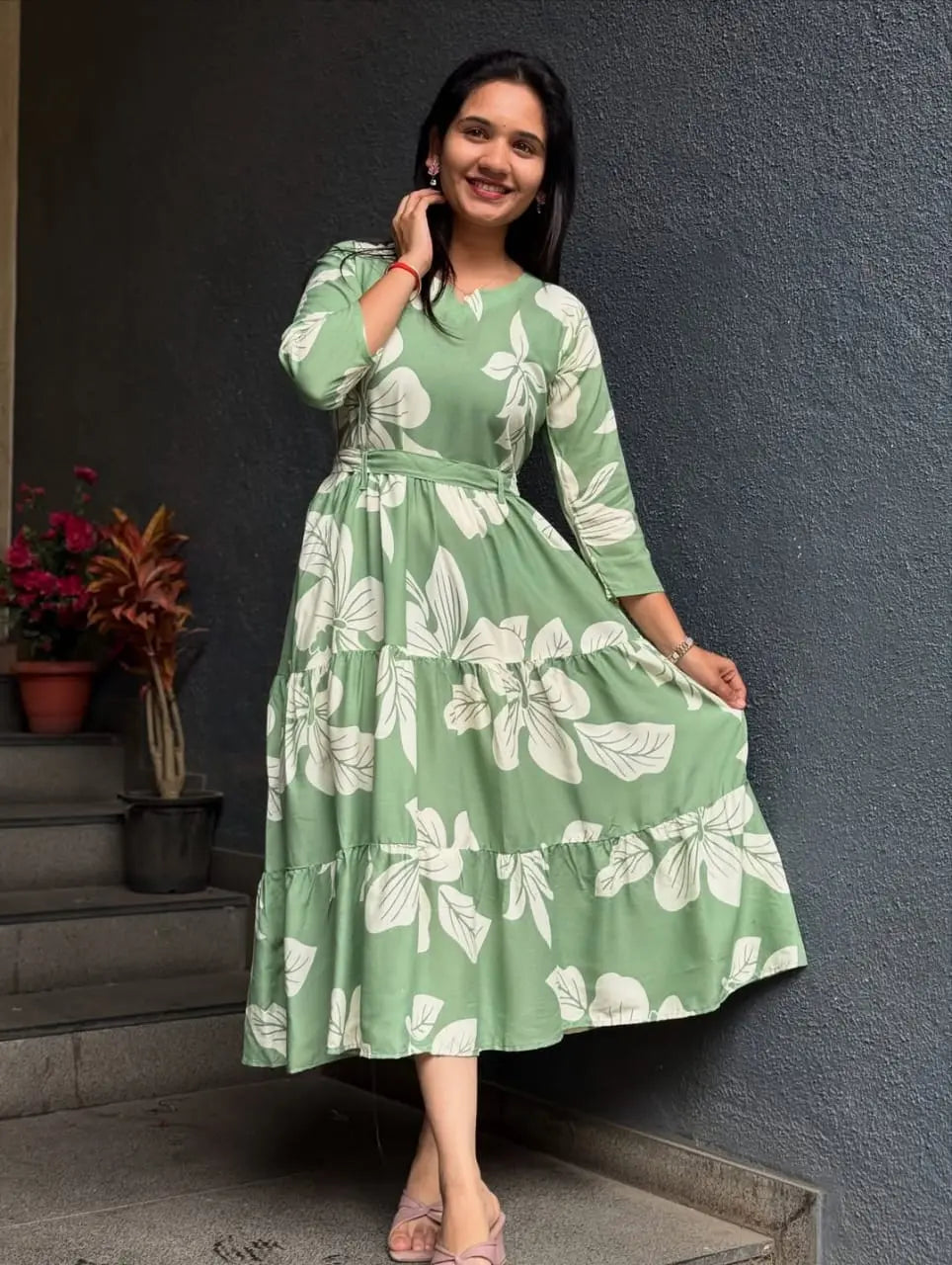 Green midi dress with white floral print, long sleeves, and a fitted waist.