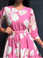 Pink short dress with white floral print and three-quarter sleeves, cinched waist detail.