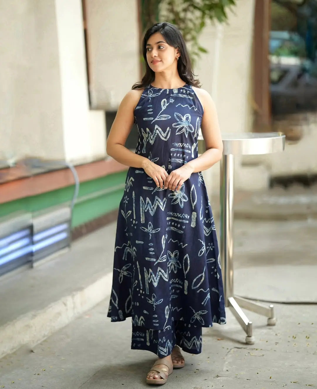 Sleeveless navy blue dress with white abstract floral and geometric print, midi length.