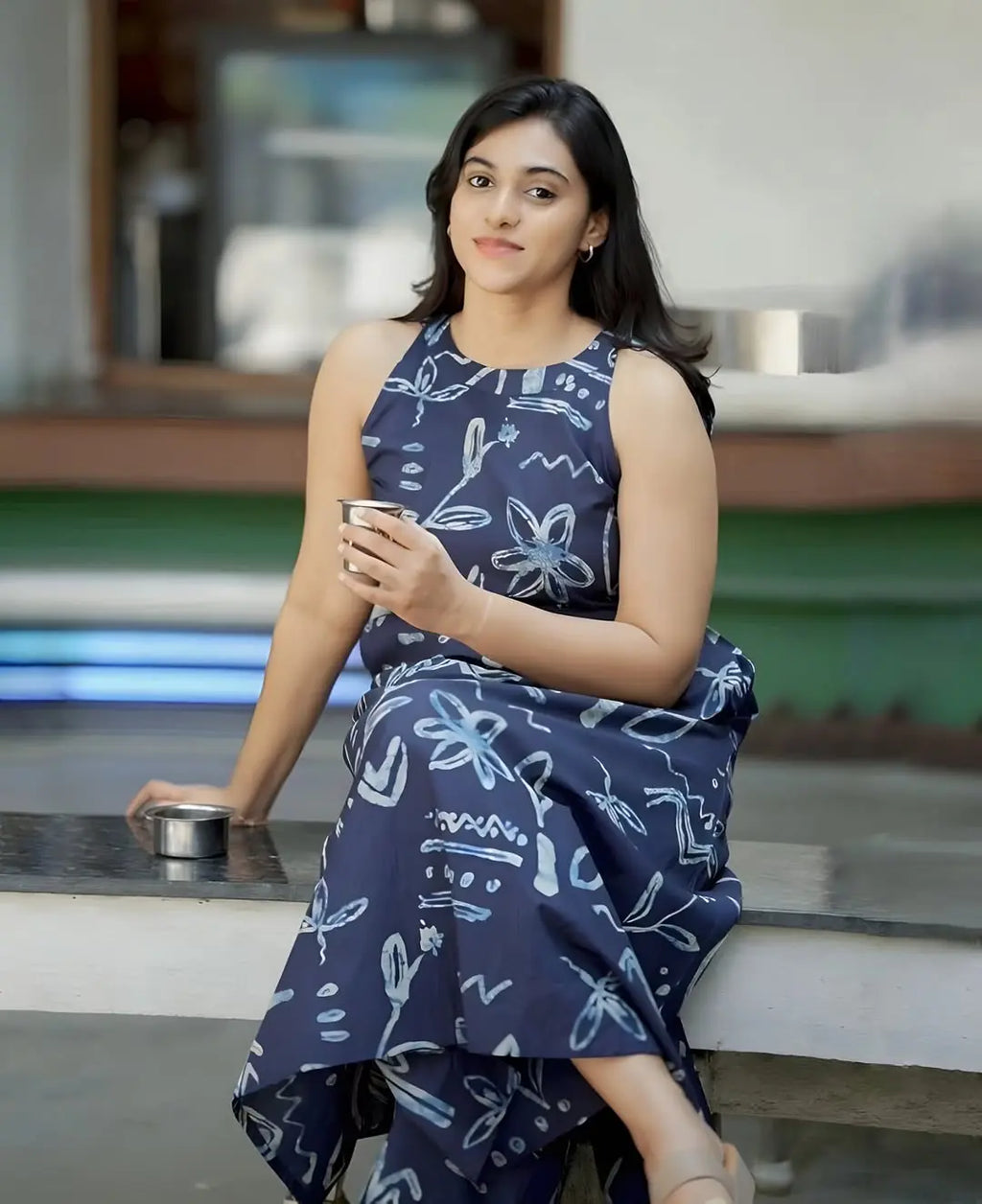 Navy blue sleeveless dress with white floral and text prints, ankle-length, flowy design.