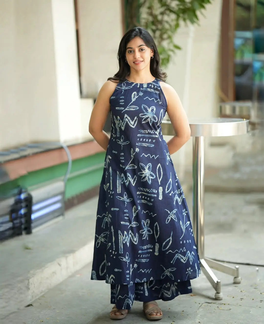 Navy blue sleeveless maxi dress with abstract white line art designs and side pockets.