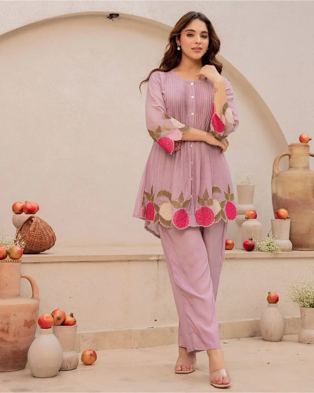 Lavender cotton kurta with floral embroidery and matching straight pants, worn with pink bangles.