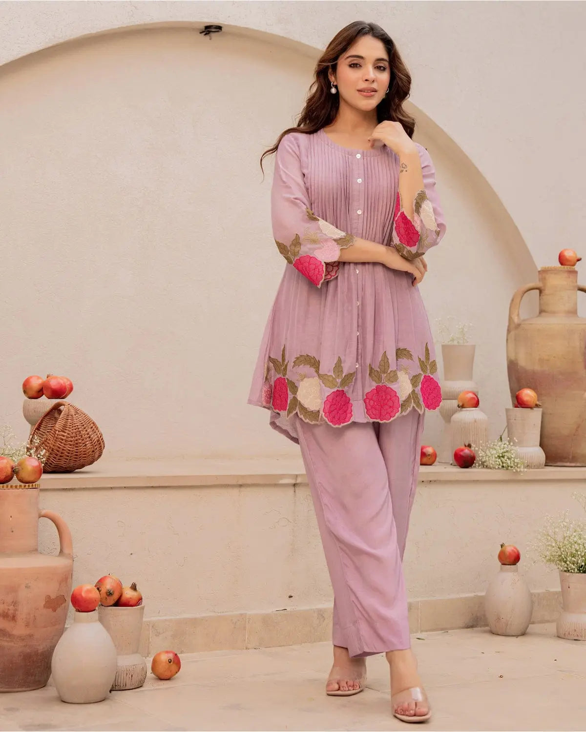 Lavender cotton kurta with floral embroidery and matching straight pants, worn with pink bangles.
