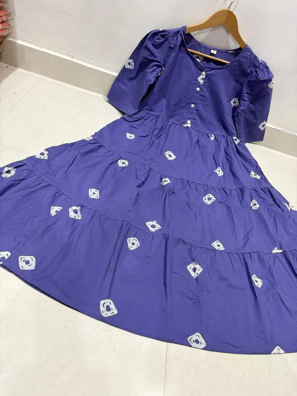 Purple midi dress with puff sleeves and white floral prints, gathered waist.