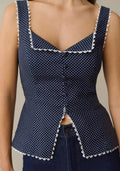 Navy blue sleeveless peplum top with white polka dots and scalloped trim on neckline and hem.