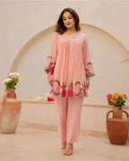 Peach cotton kurta with floral embroidery and matching straight pants worn with sandals.