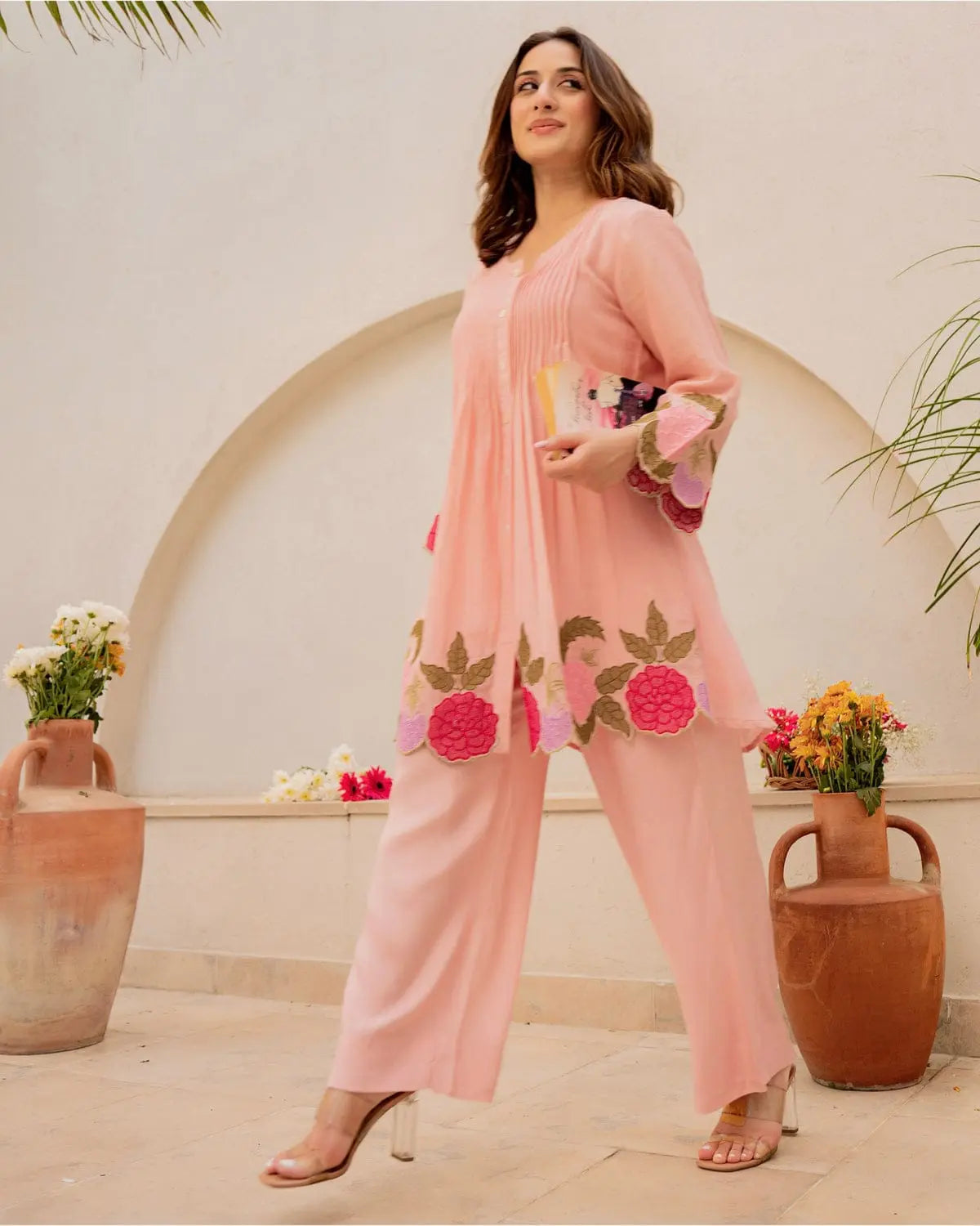 Peach cotton kurta with floral embroidery paired with matching wide-leg pants and nude heels.