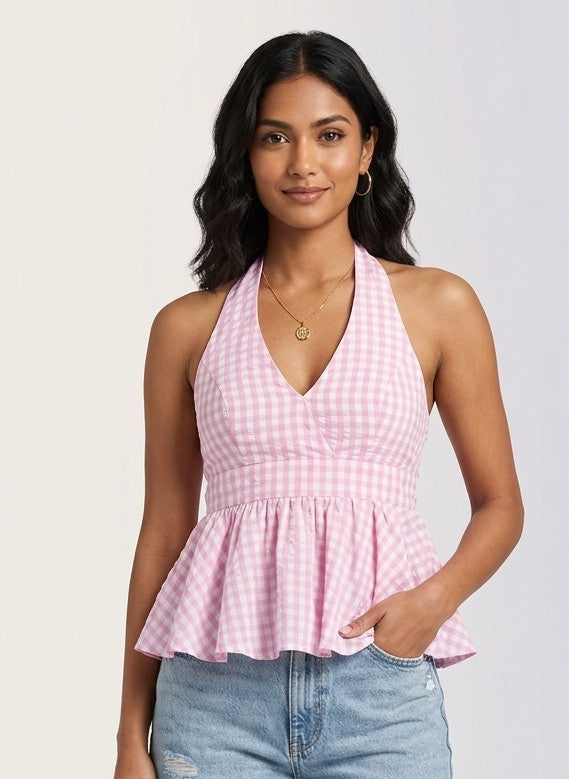 Woman wearing a pink checkered halter top and blue jeans on a white background