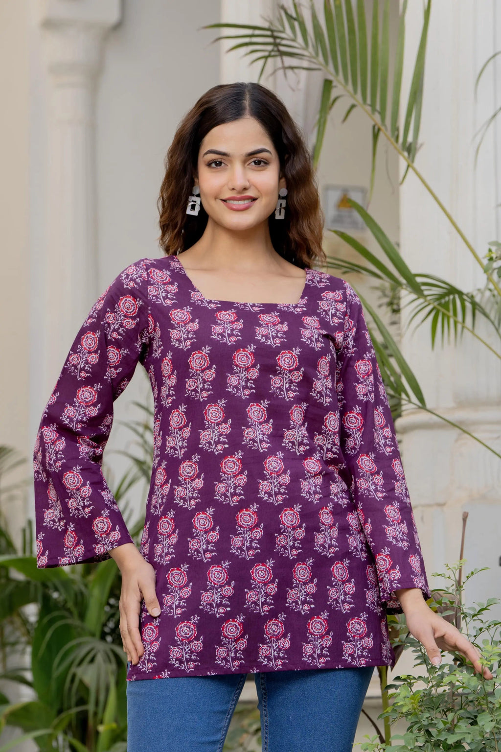 Purple cotton kurti with square neckline, floral print, and flared long sleeves.