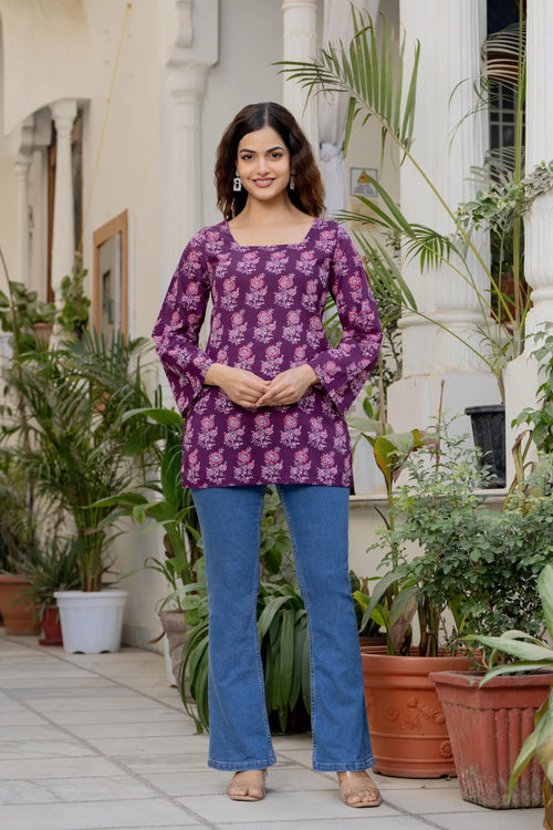 Purple cotton kurti with square neckline and flared sleeves featuring a light floral print, paired with blue pants.