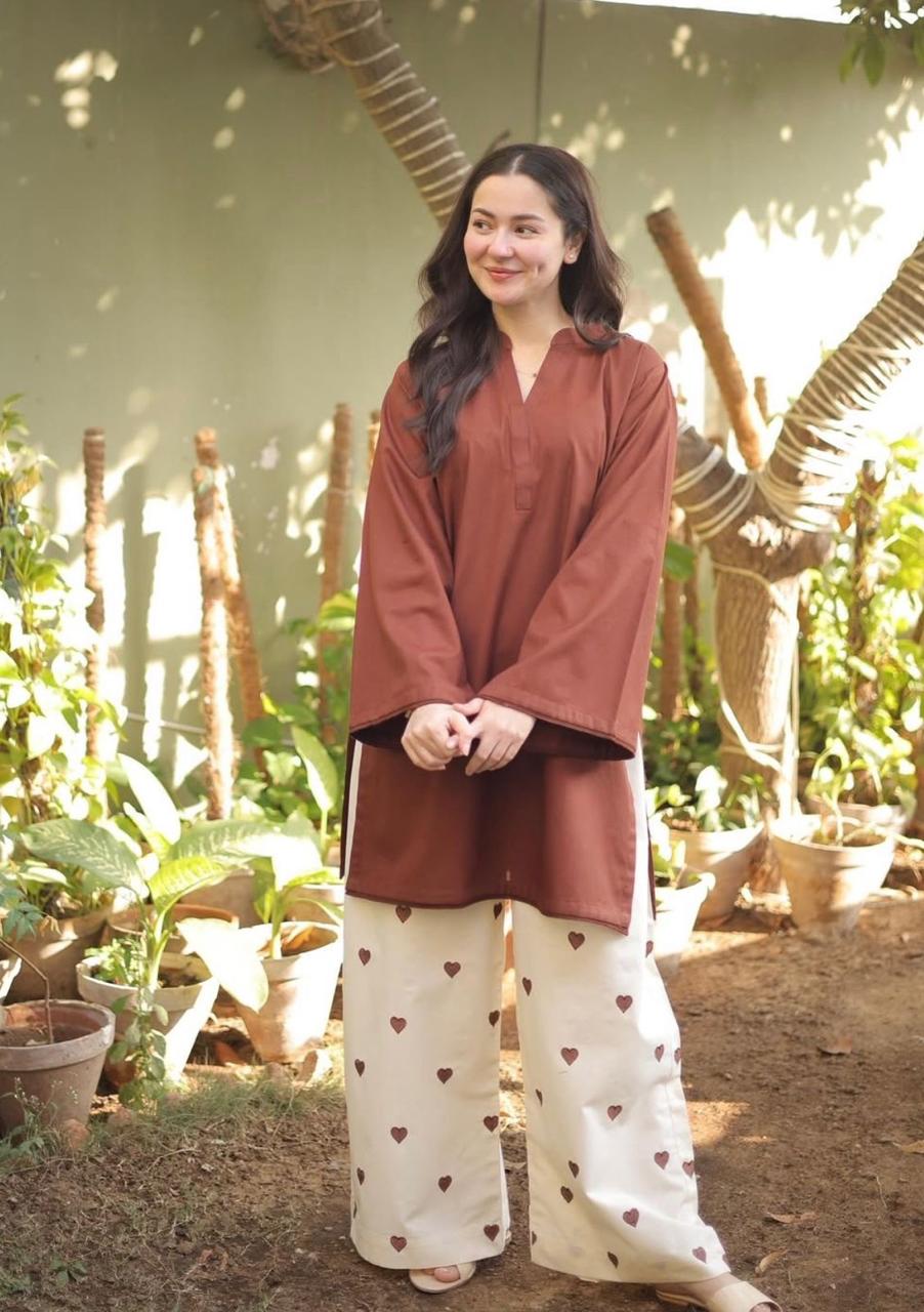Brown long-sleeve tunic with v-neck paired with white wide-leg pants featuring brown floral prints.