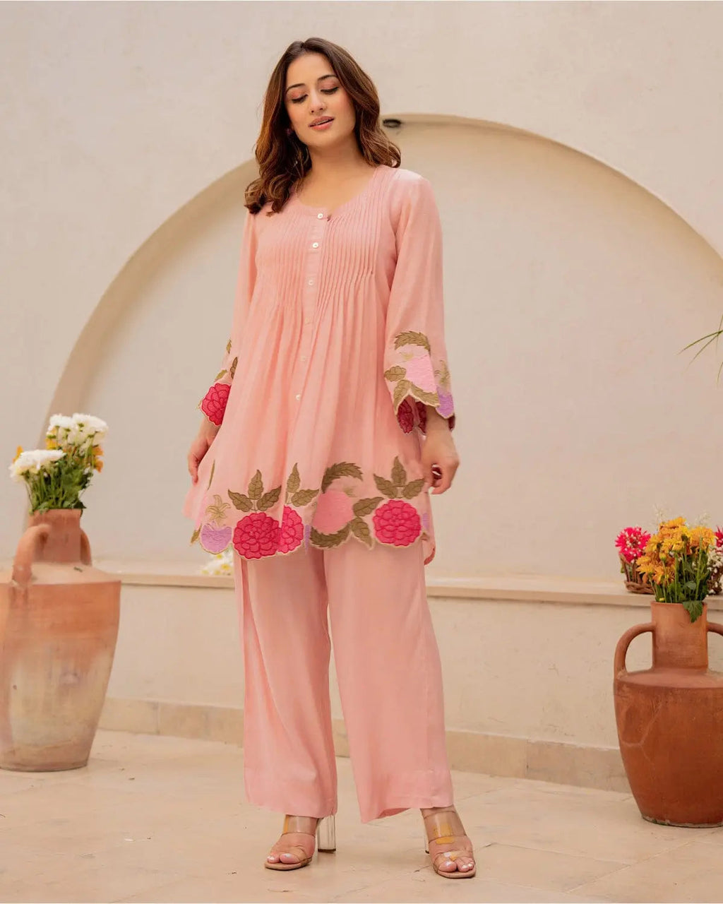 Peach cotton kurta with floral embroidery and matching wide-leg pants on model.