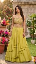 Yellow floral embroidered halter neck crop top with matching layered lehenga skirt.